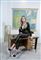 Mille Dinesen sidder på et kateder foran et Danmarks kort 