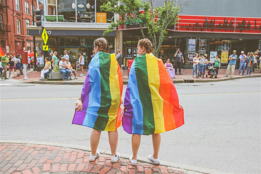 to kvinder svøbt i regnbueflag