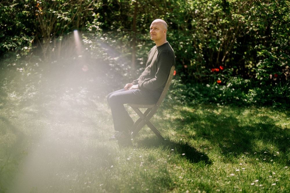Mand sidder på stol i solen