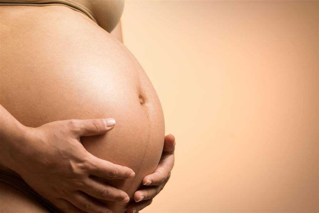 Kvinde holder om gravid mave