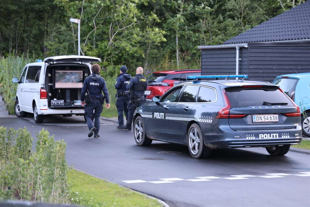 Politibetjente og politibiler på en vej.
