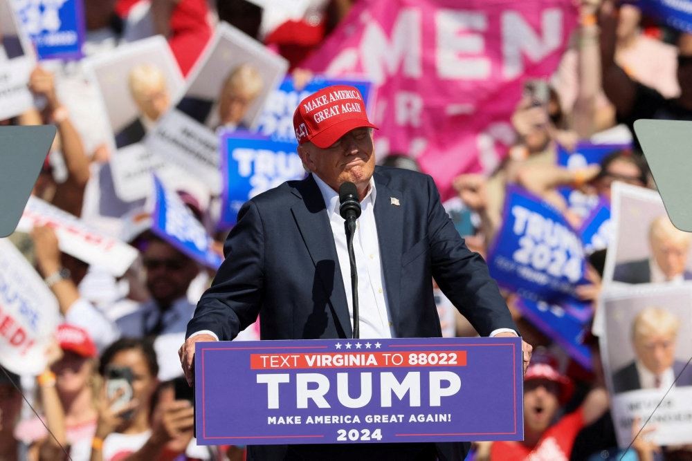 Donald Trump på talerstol med rød kasket