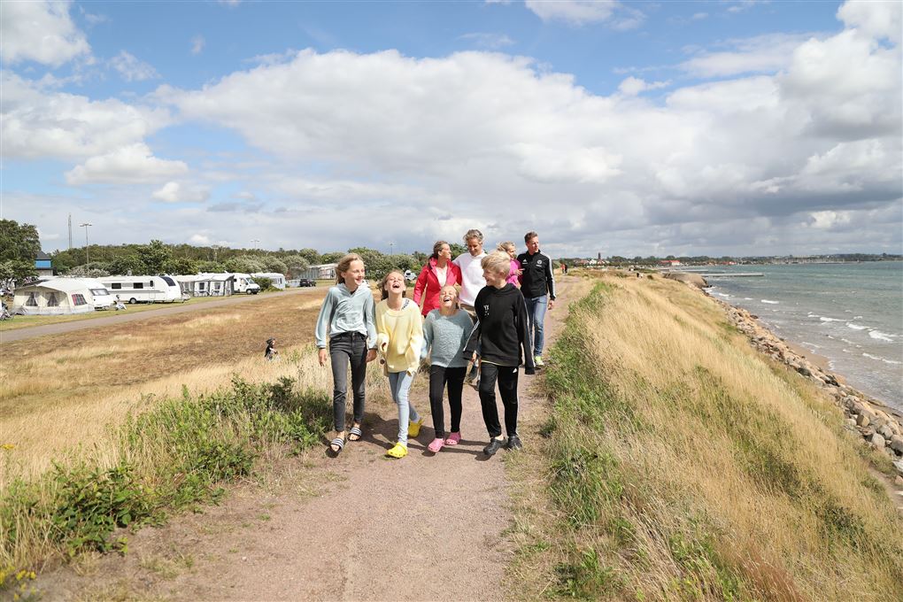 glade mennesker på en strand i blæsevejr