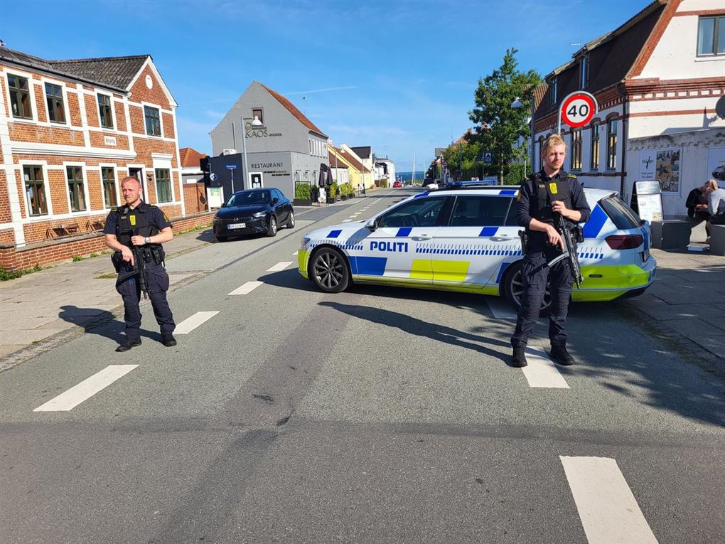 Betjente med våben og afspærring.