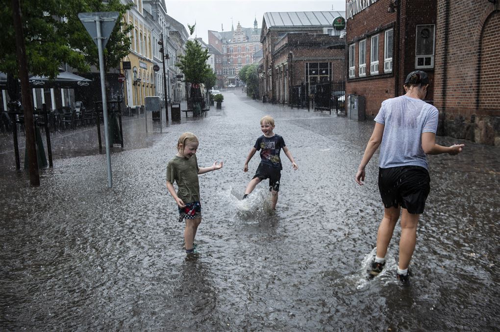 børn leger i vand på vej