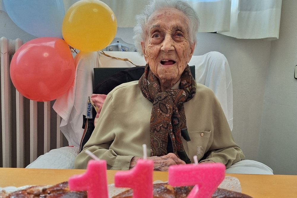 Ældre kvinde med lagkage med lys i