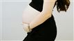 En gravid mave og en kvinde som holder på den.