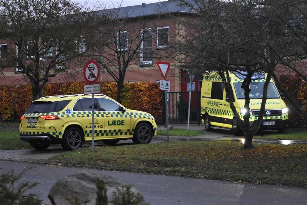 politi og ambulance parkeret foran hus