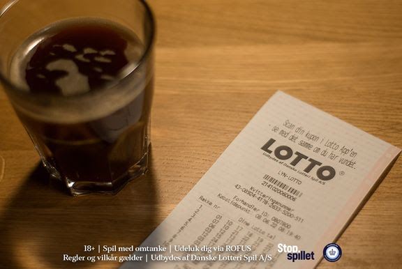 lottokupon ligger på bord ved siden af en kop kaffe