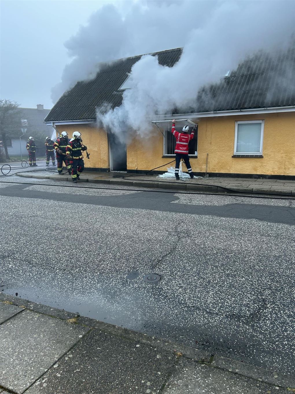 Brandfolk ved brændende hus