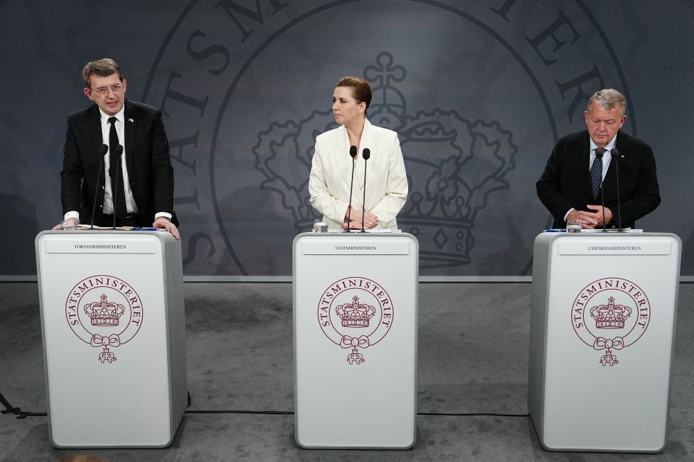 De tre regeringschefer står bag hver sit høje, hvide bord til pressemøde