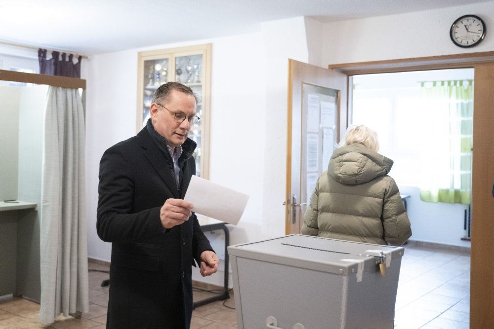 mand står ved stemmeboks og afgiver sin stemme
