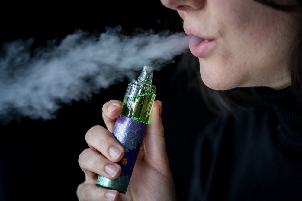 En mund der puster damp ud efter en e-cigaret