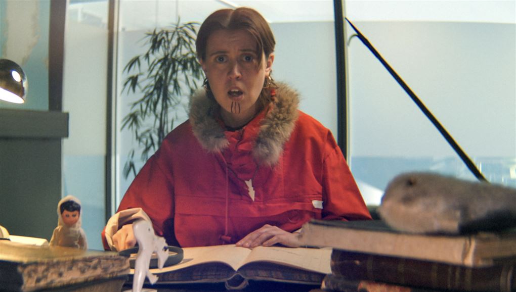 en pige i anorak ved et bord