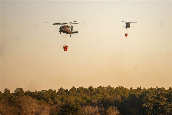 helikopter i luften med kæmpe vandbeholder