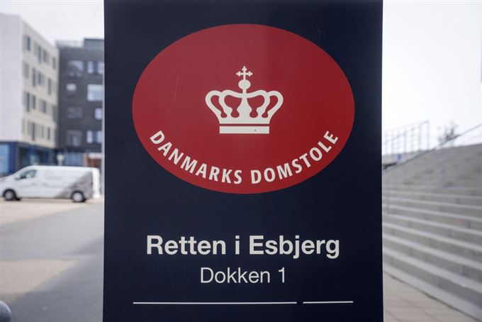 rødt logo med tekst hænger på bygning