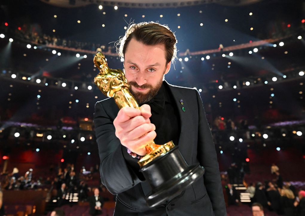 en mand med en Oscar-statuette
