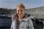 Smilende kvinde i dunjakke ved havnebad