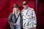 En kvinde med cowboyhat og mand med kasket på rød løber 