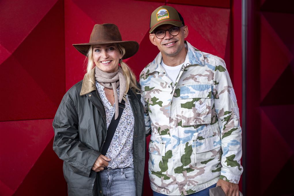 En kvinde med cowboyhat og mand med kasket på rød løber 