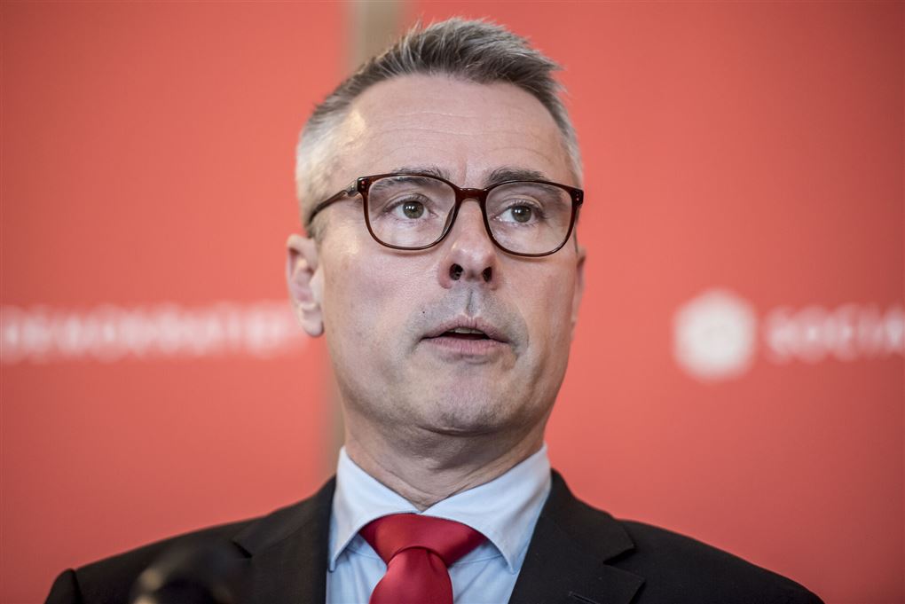 Mand i jakke og rødt slips mod en rød baggrund