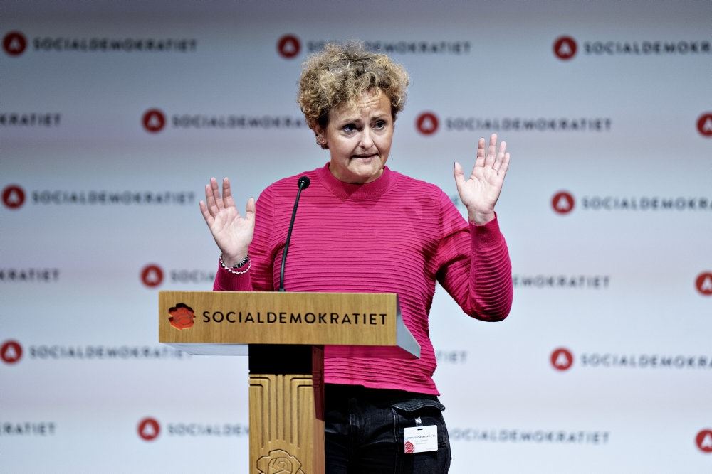 kvinde i lyserød trøje på talerstol