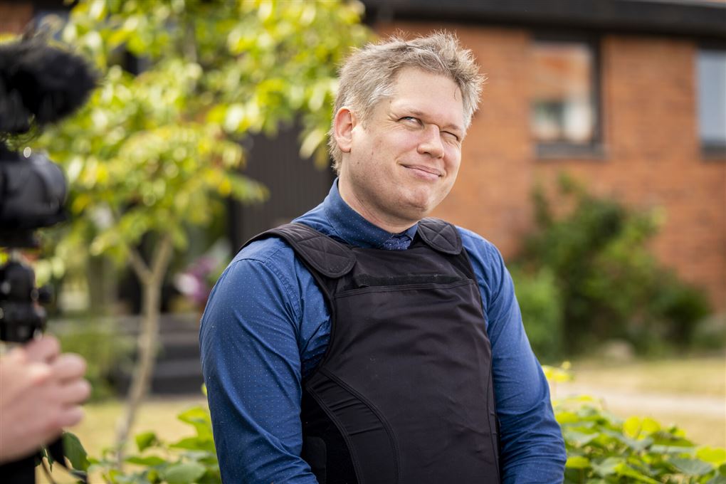 en smilende mand i skudsikker vest