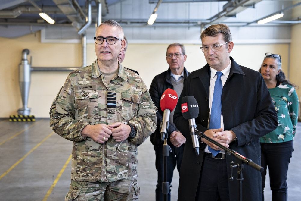 to mænd i jakkesæt og en enkelt i uniform