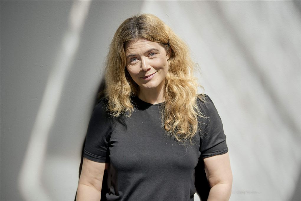 Kvinde med udslået hår i mørk t-shirt