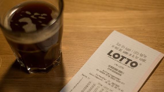 Lottokupon og glas med kaffe på bord