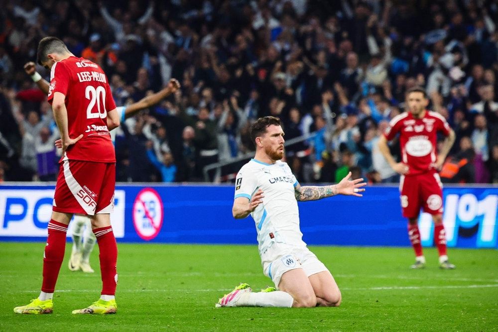 fodboldspiller i hvidt på knæ