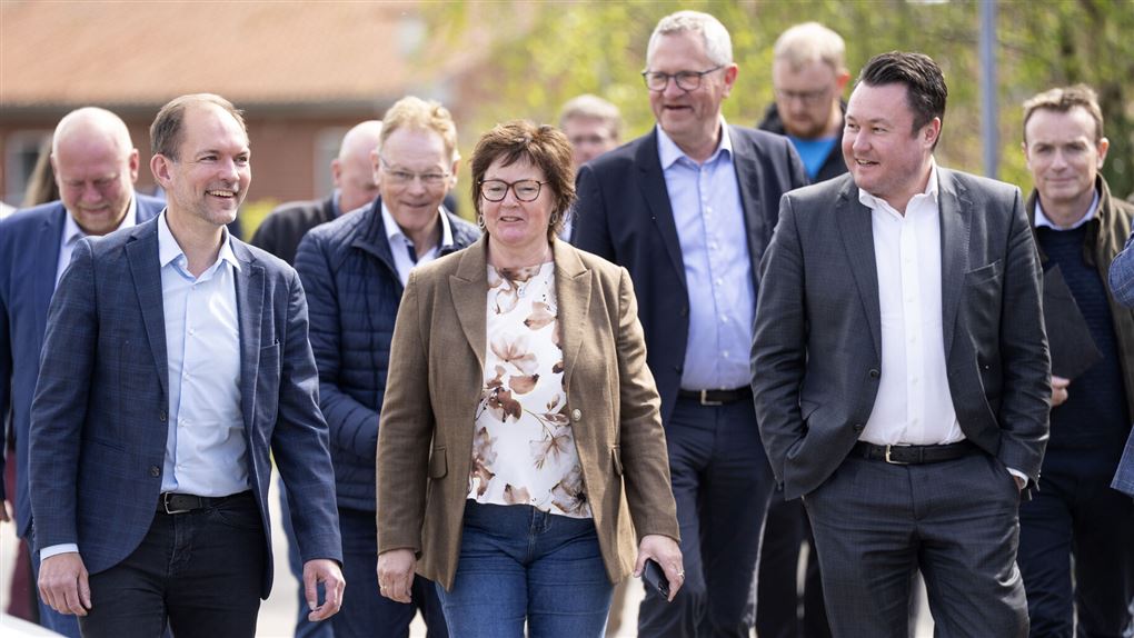 en række personer kommer gående