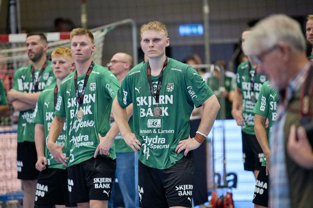 håndboldspillere står på banen