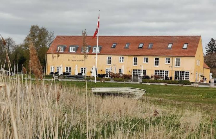 En stor gul bygning med rødt tag