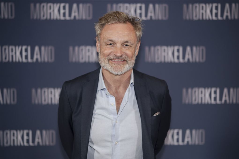 Claus Elming smilende og afslappet med hænderne bag ryggen til en premiere
