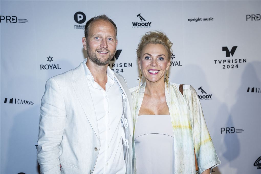 Mand og kvinde smiler på den røde løber