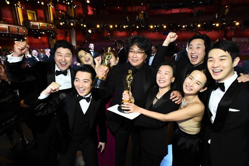 mennesker står med oscarstatuette