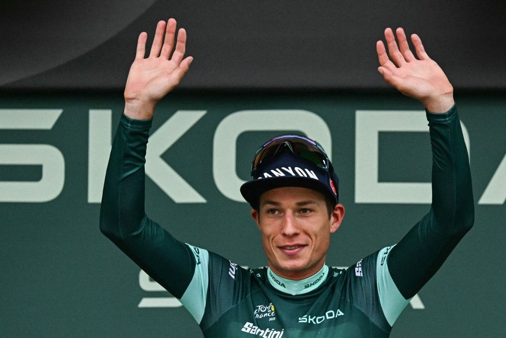 cykelrytter med hænderne over hovedet