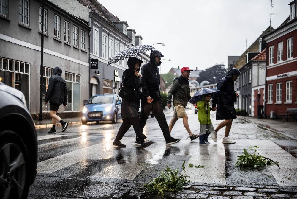 folk går over gade i regnvejr 