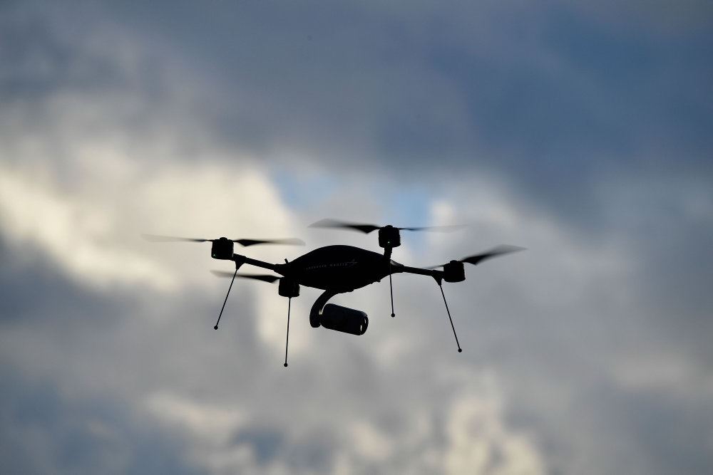 En drone på himlen med skyer som baggrund