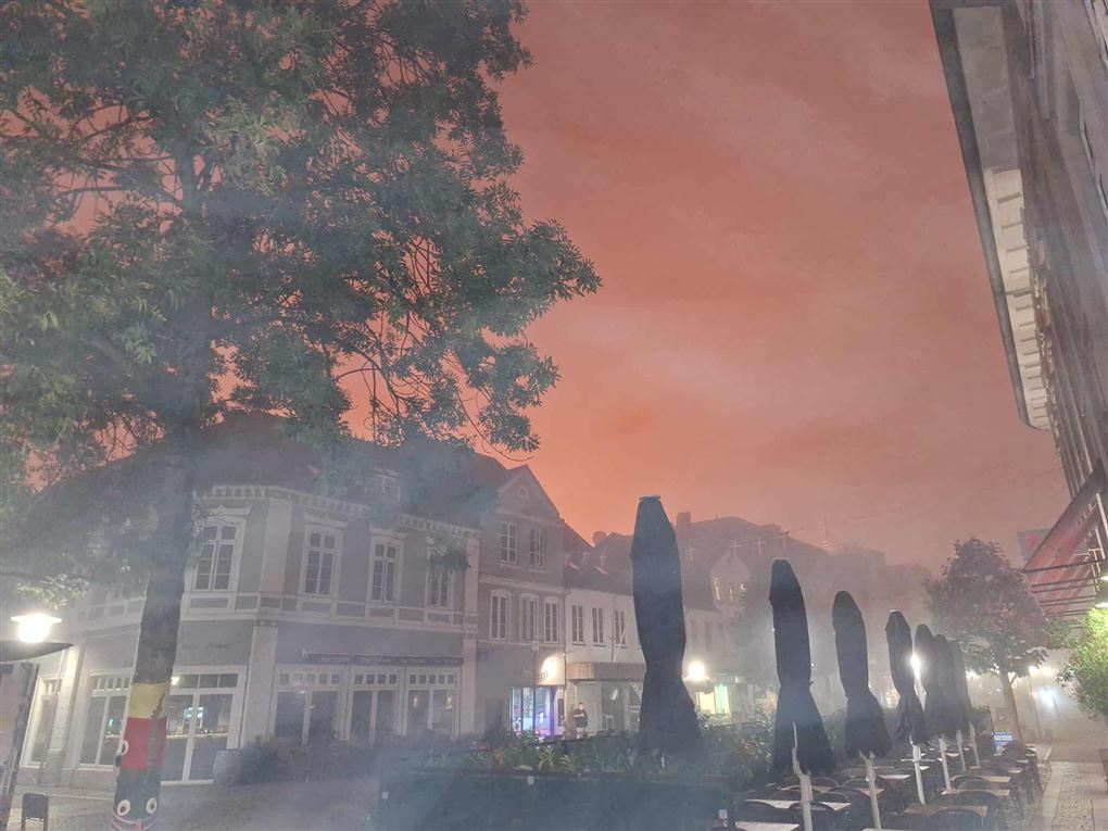 Orangerød himmel ses bag bygning