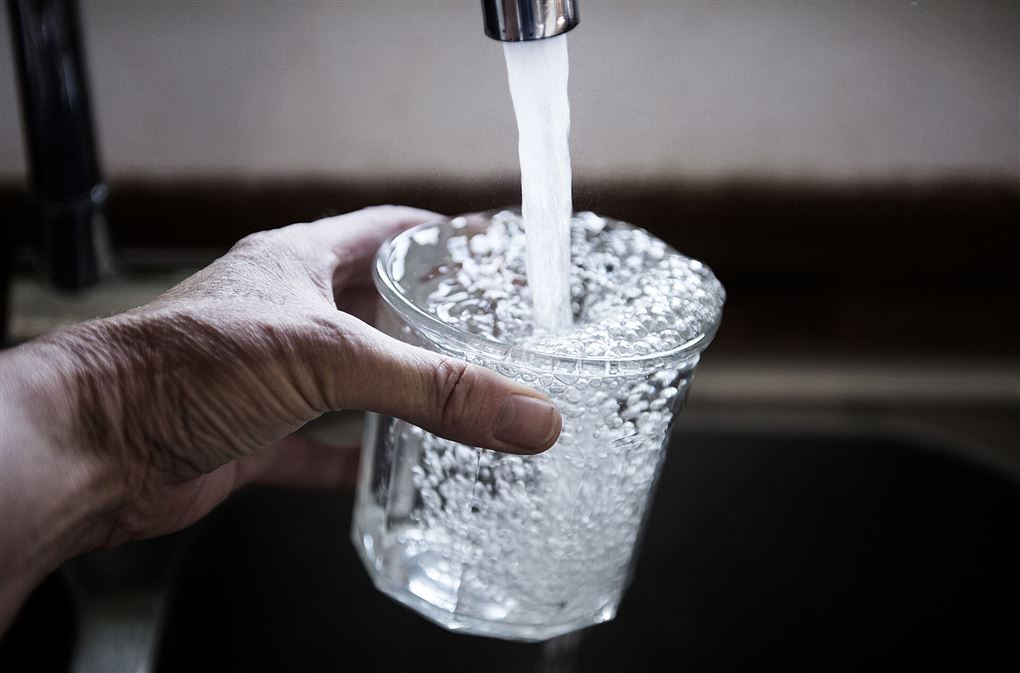 et glas fyldes med vand fra hanen
