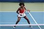 Venus Williams i rød top og hvid underdel på tennisbanen