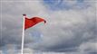 et rødt flag på en strand
