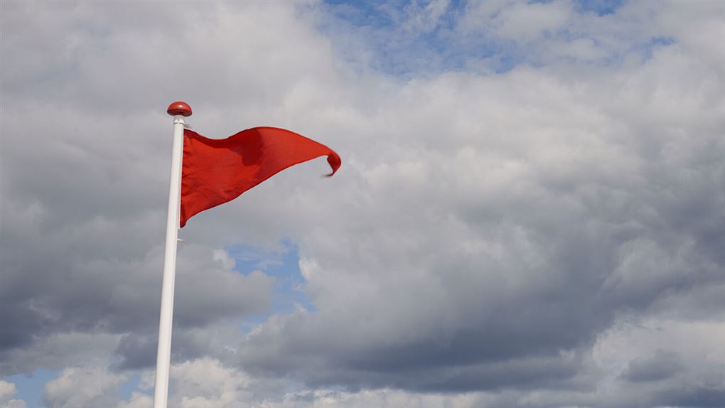 et rødt flag på en strand