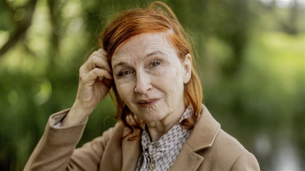 rødhåret kvinde tager sig til hovedet