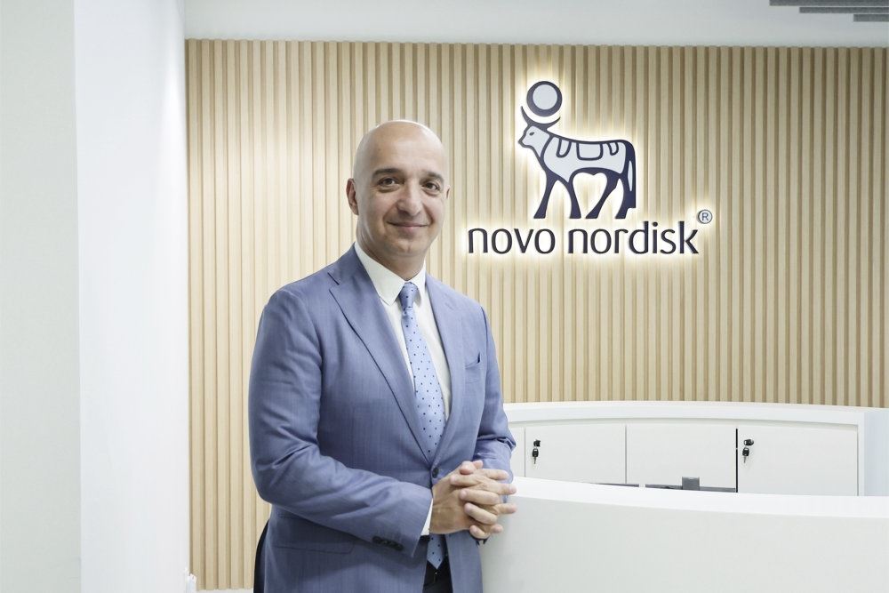 mand foran væg med novo logo