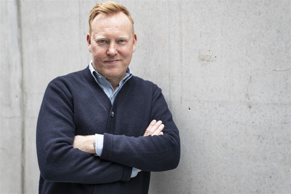 Anders Breinholt op ad en hvid væg i mørk trøje med armene over kors