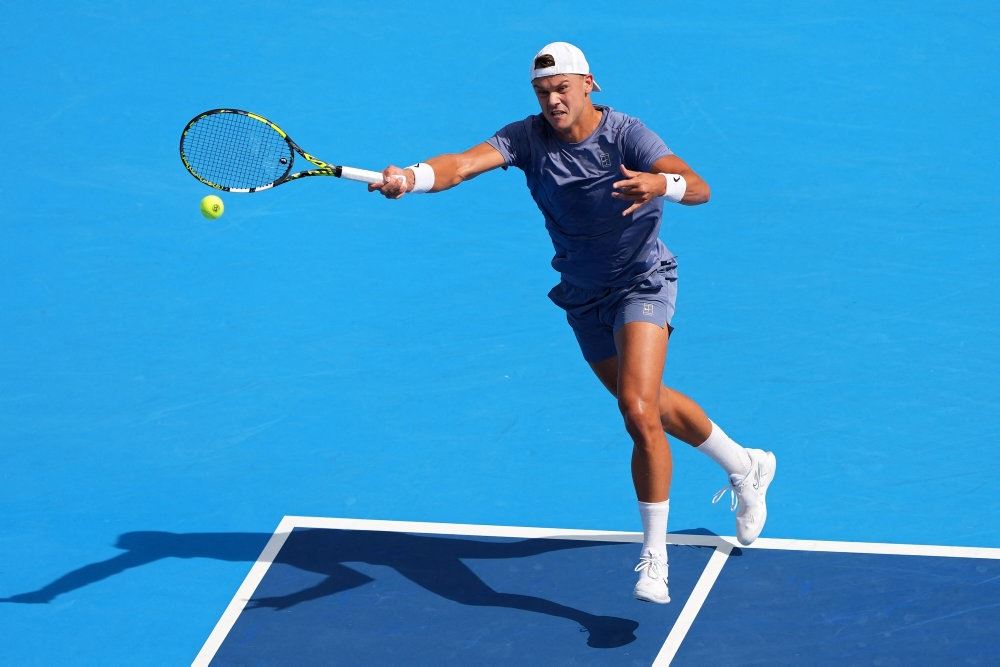 tennisspiller returnerer bolden